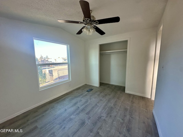 unfurnished bedroom with hardwood / wood-style floors, ceiling fan, a closet, lofted ceiling, and a textured ceiling