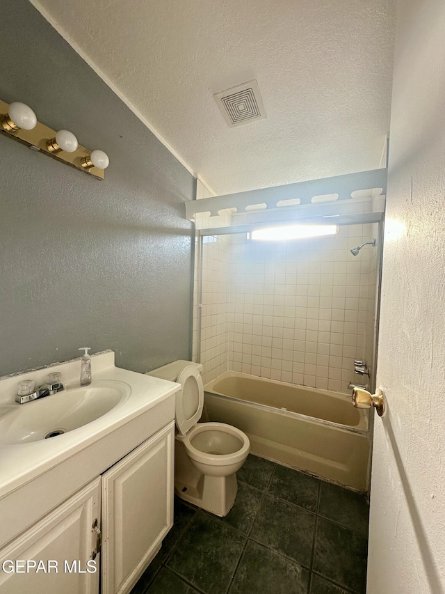 full bathroom featuring toilet, tiled shower / bath, vanity, and a textured ceiling