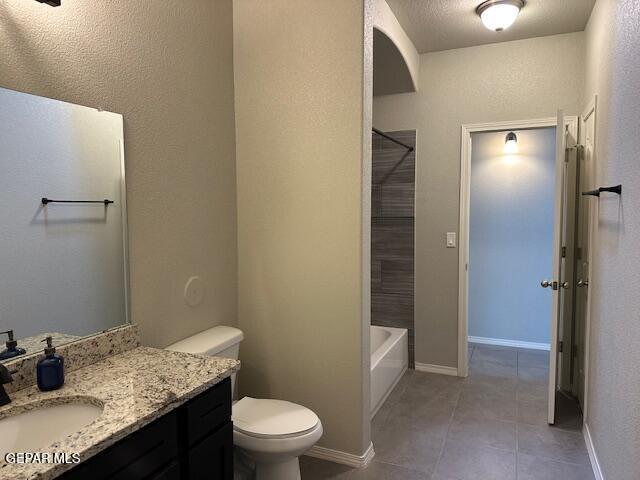 full bathroom with a textured ceiling, tile patterned flooring, vanity, shower / bath combination, and toilet