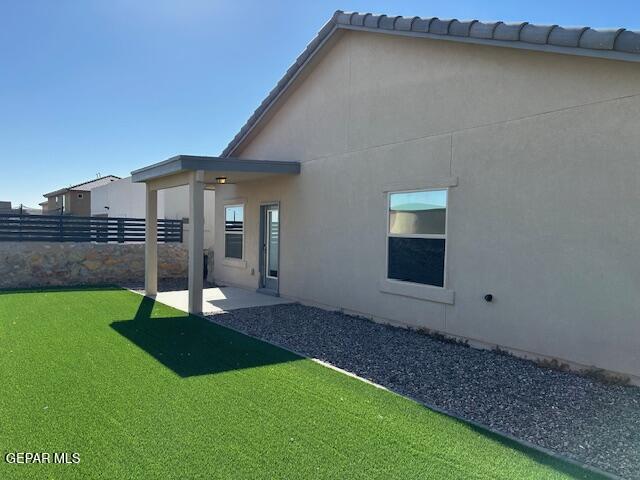 rear view of house featuring a yard and a patio