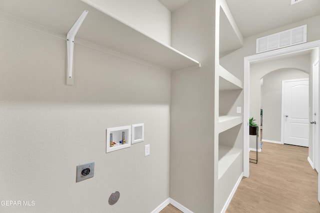 laundry room featuring crown molding, washer hookup, light wood-type flooring, built in shelves, and hookup for an electric dryer