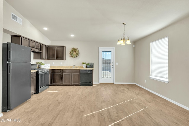 kitchen featuring black appliances, light wood-type flooring, dark brown cabinetry, an inviting chandelier, and pendant lighting