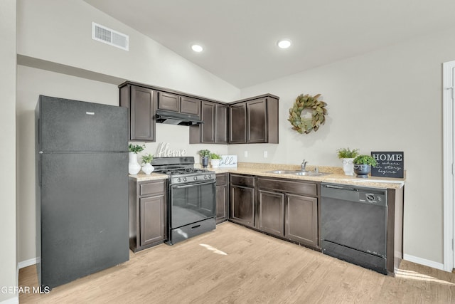 kitchen featuring dark brown cabinetry, black appliances, vaulted ceiling, sink, and light wood-type flooring