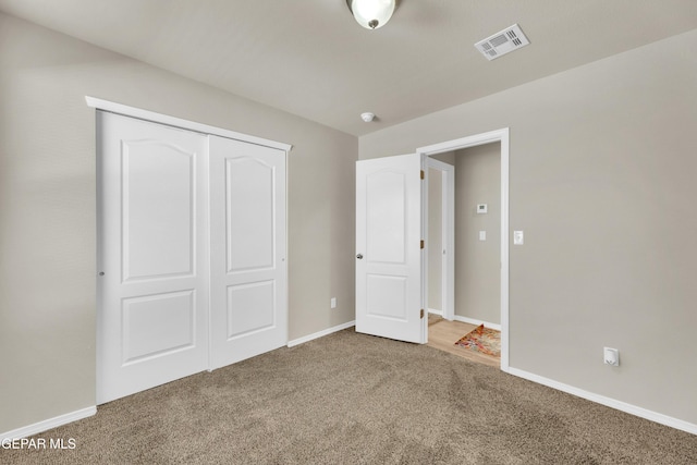 unfurnished bedroom with a closet and carpet flooring