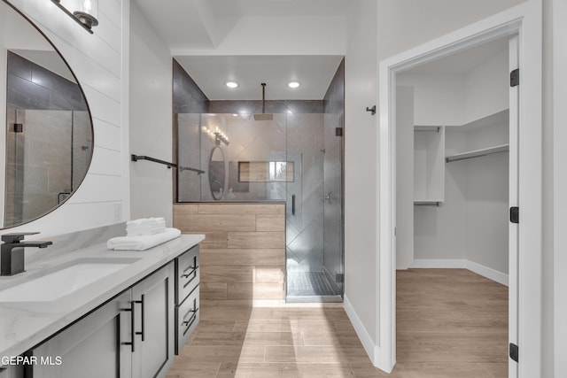 bathroom featuring vanity, wood-type flooring, and walk in shower