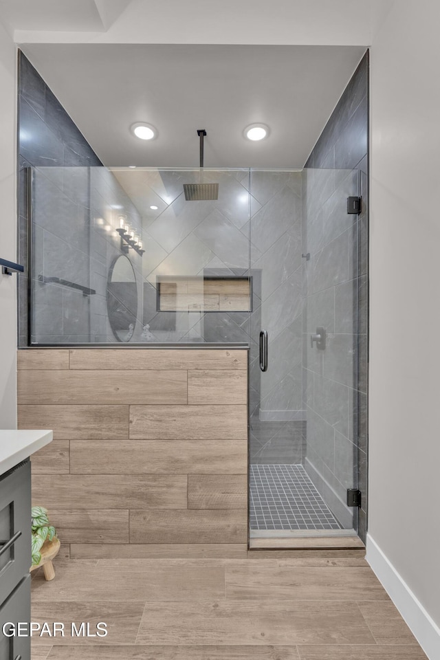 bathroom featuring vanity and a shower with shower door