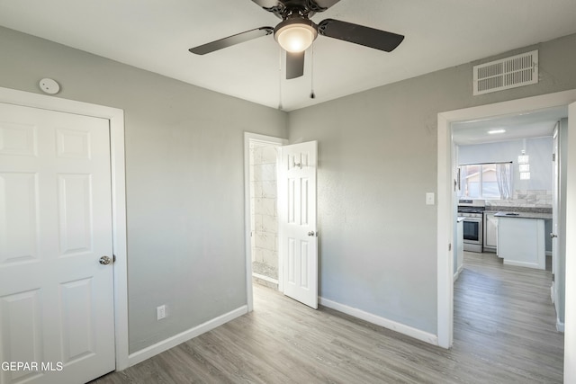 unfurnished bedroom featuring light wood-style flooring, visible vents, ceiling fan, and baseboards