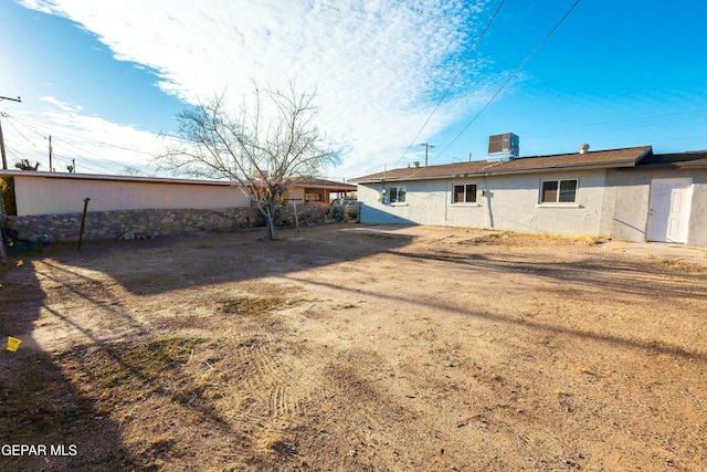 back of house featuring central AC unit and a lawn