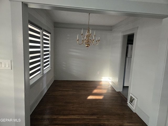 corridor featuring dark wood-type flooring and a chandelier