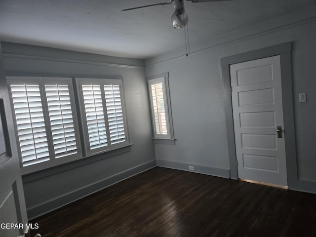 empty room with ceiling fan and dark hardwood / wood-style flooring