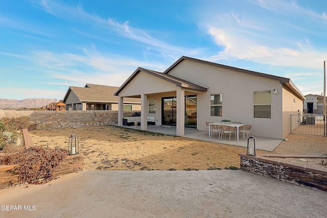 back of property with a patio area and a mountain view