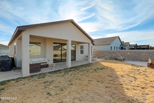 back of house featuring a lawn and a patio area