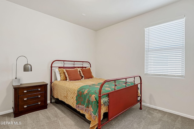 bedroom featuring light colored carpet and multiple windows