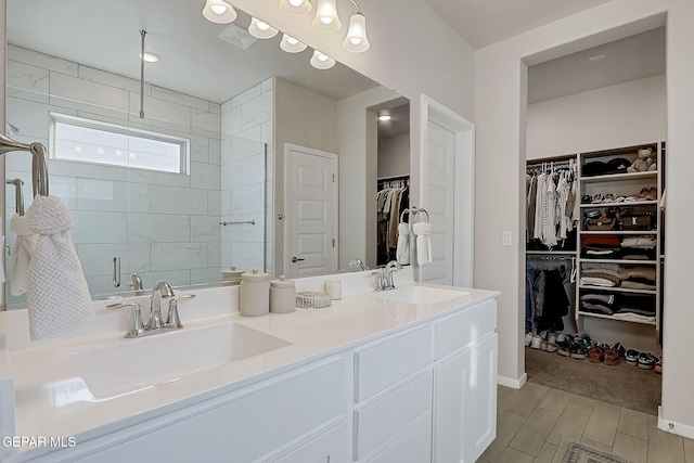 bathroom featuring a shower with door and vanity