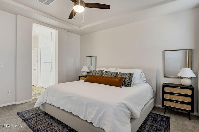 bedroom featuring light carpet, ceiling fan, connected bathroom, and a raised ceiling