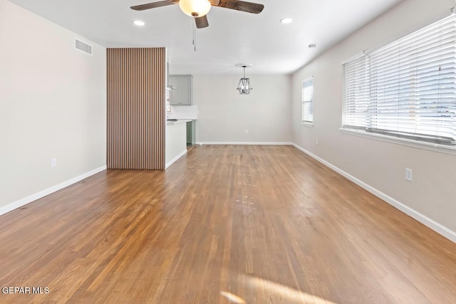 unfurnished living room with ceiling fan and hardwood / wood-style floors