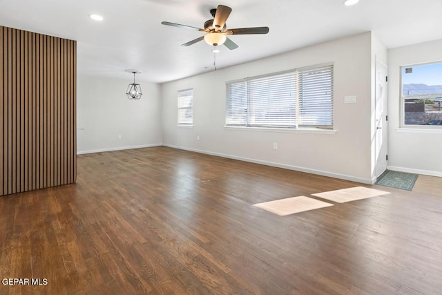 unfurnished room featuring dark hardwood / wood-style floors, a wealth of natural light, and ceiling fan