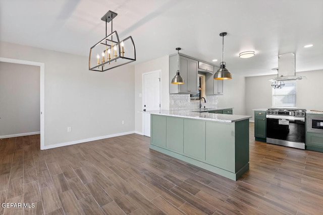 kitchen with appliances with stainless steel finishes, tasteful backsplash, sink, kitchen peninsula, and green cabinets