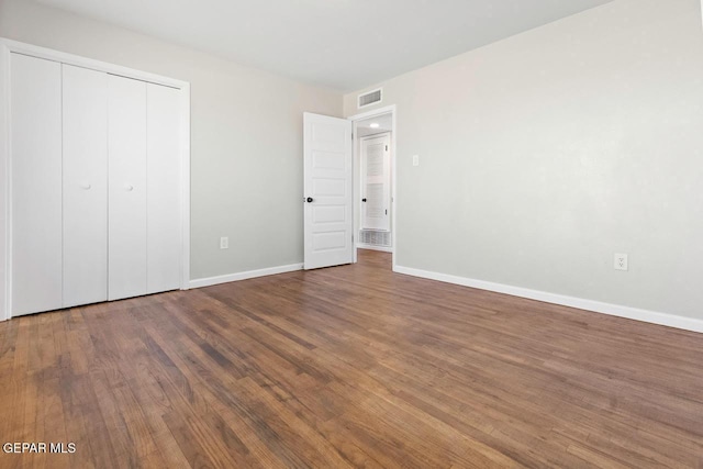 unfurnished bedroom featuring a closet and hardwood / wood-style flooring