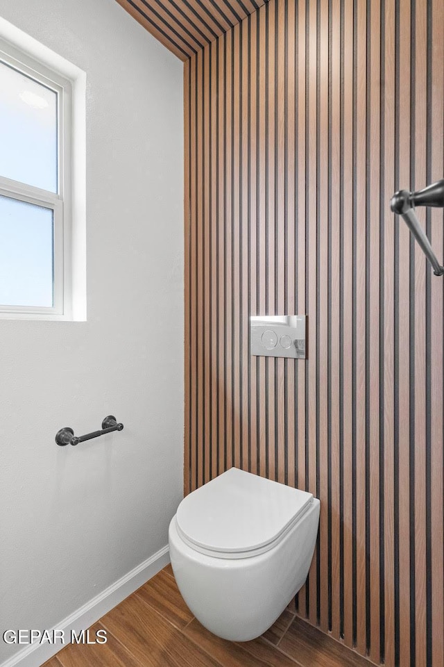 bathroom featuring toilet and wood-type flooring