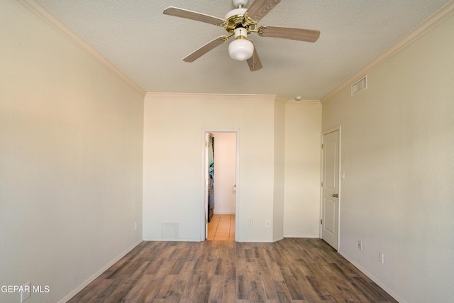 empty room featuring a textured ceiling, dark wood-type flooring, crown molding, and ceiling fan