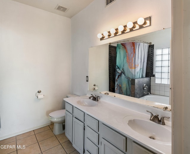 bathroom with toilet, vanity, and tile patterned floors