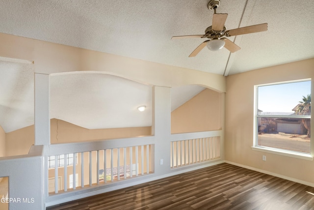 additional living space featuring ceiling fan, a textured ceiling, dark hardwood / wood-style floors, and vaulted ceiling