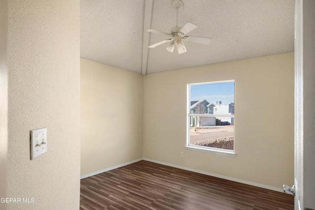 spare room featuring ceiling fan, a textured ceiling, dark hardwood / wood-style floors, and vaulted ceiling