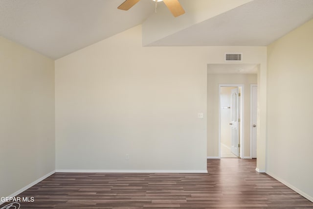 spare room with ceiling fan, vaulted ceiling, and dark wood-type flooring