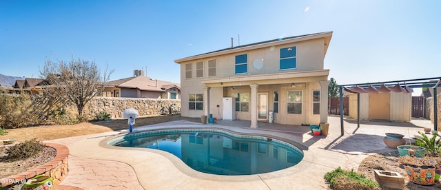 rear view of house featuring a fenced in pool, a pergola, and a patio