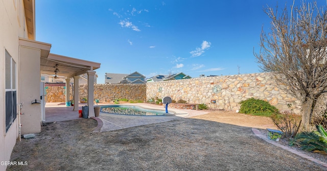 view of yard with ceiling fan, a fenced in pool, and a patio