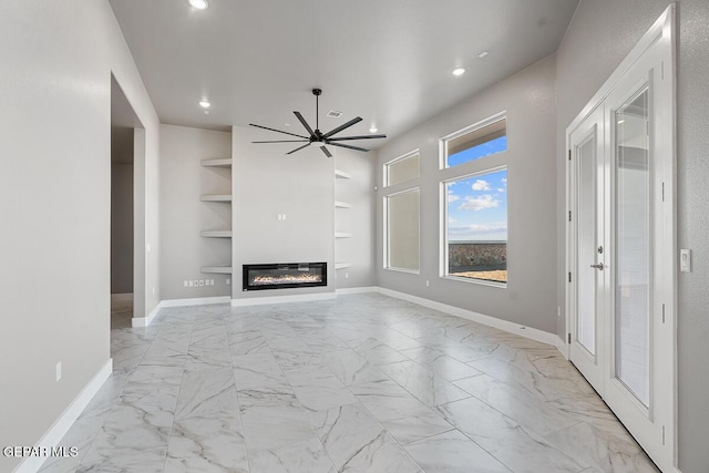 unfurnished living room featuring ceiling fan and built in shelves