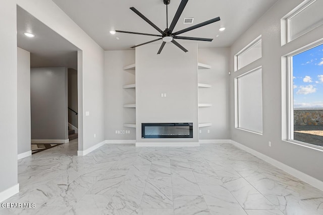 unfurnished living room featuring ceiling fan and built in shelves