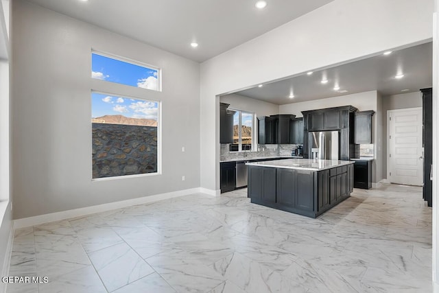 kitchen with stainless steel appliances, tasteful backsplash, and a center island