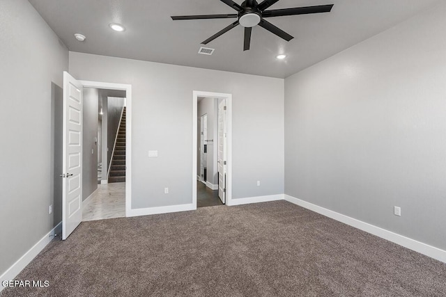 unfurnished bedroom featuring ceiling fan, ensuite bath, and carpet flooring