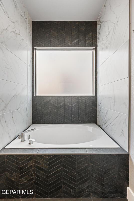 bathroom with tiled bath and tile walls