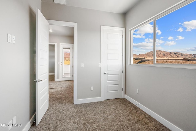 unfurnished bedroom featuring carpet and a mountain view