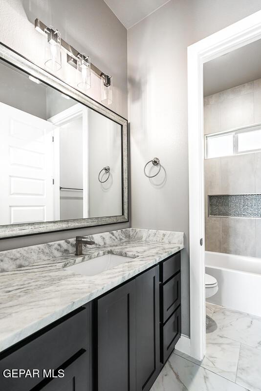 full bathroom featuring washtub / shower combination, toilet, and vanity