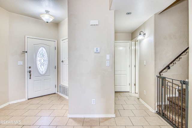 foyer entrance with light tile patterned floors