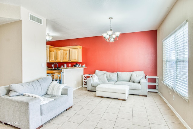 living room featuring a notable chandelier, a wealth of natural light, sink, and light tile patterned flooring