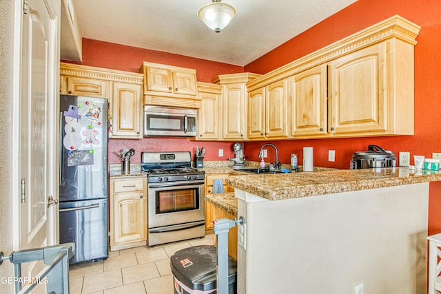 kitchen featuring appliances with stainless steel finishes, light brown cabinets, sink, kitchen peninsula, and light tile patterned floors