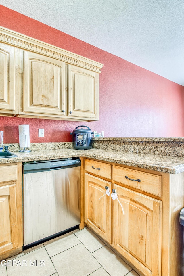 kitchen featuring light brown cabinets, dishwasher, sink, light tile patterned floors, and a textured ceiling