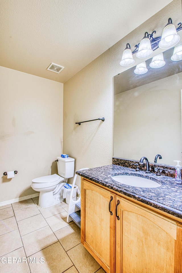 bathroom featuring a textured ceiling, toilet, vanity, and tile patterned flooring