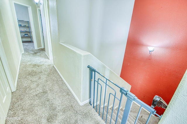 hallway featuring light colored carpet