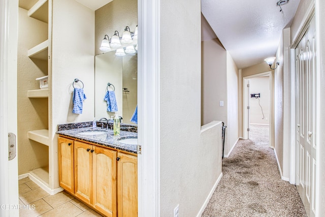 bathroom with built in features, a textured ceiling, and vanity