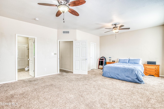 bedroom with ceiling fan, ensuite bath, and light carpet