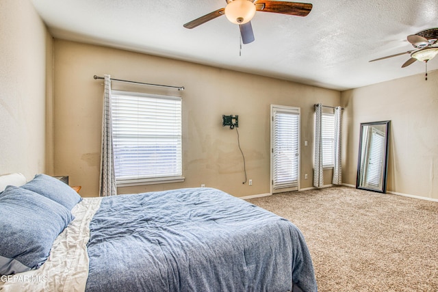 bedroom featuring a textured ceiling, carpet flooring, and ceiling fan