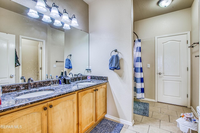 bathroom with a textured ceiling, walk in shower, vanity, and tile patterned flooring