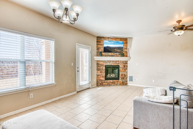 living room featuring ceiling fan with notable chandelier, a stone fireplace, and light tile patterned flooring