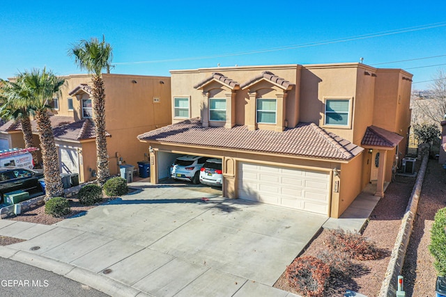 view of front of home featuring a garage and central AC